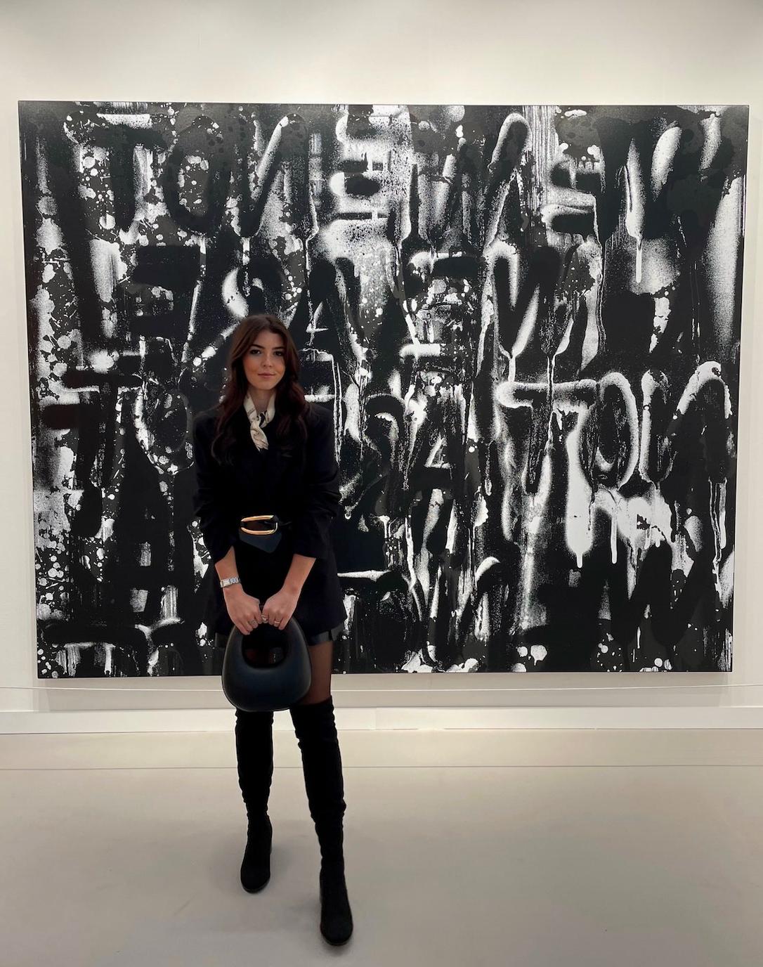 Art history alum Elise Huff (B.A. '20) poses in an art gallery.